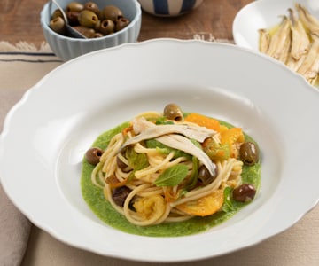 Spaghetti with zucchini cream, yellow cherry tomatoes, and marinated anchovies