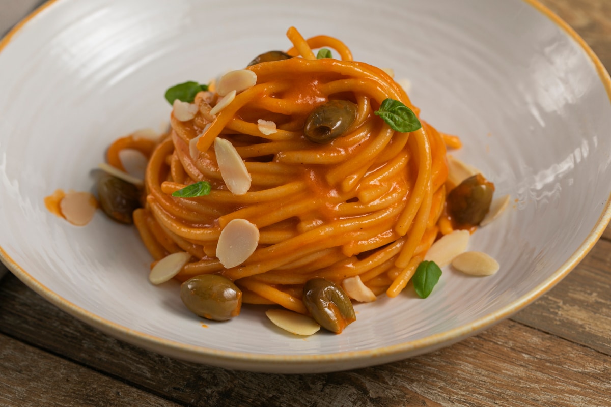 Pasta with roasted pepper cream, olives and almonds