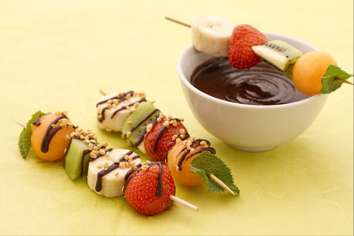 Fruit skewers with chocolate sauce and hazelnut crumble