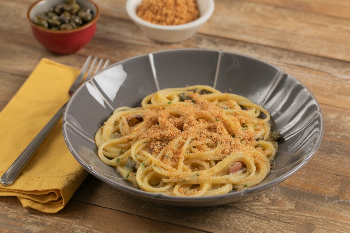 Gluten-free spaghetti with yellow cherry tomato sauce, capers, and anchovies