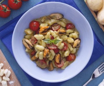Dumplings with cherry tomatoes, pesto, and mussels