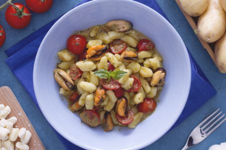Dumplings with cherry tomatoes, pesto, and mussels