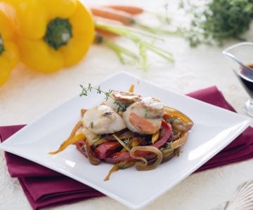 Scallops on a bed of caramelized onions with soy carrots and peppers