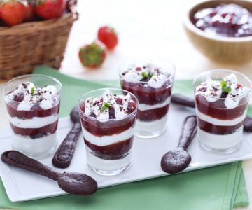 Glasses with yogurt cream, strawberry jam and cocoa sable cookies