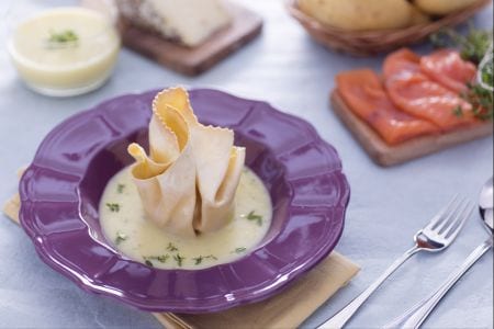 Fresh pasta bundle with salmon, toma cheese and radicchio on potato cream