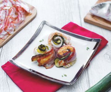 Rolled sea bass fillets with smoked bacon and grilled zucchini with Prosecco