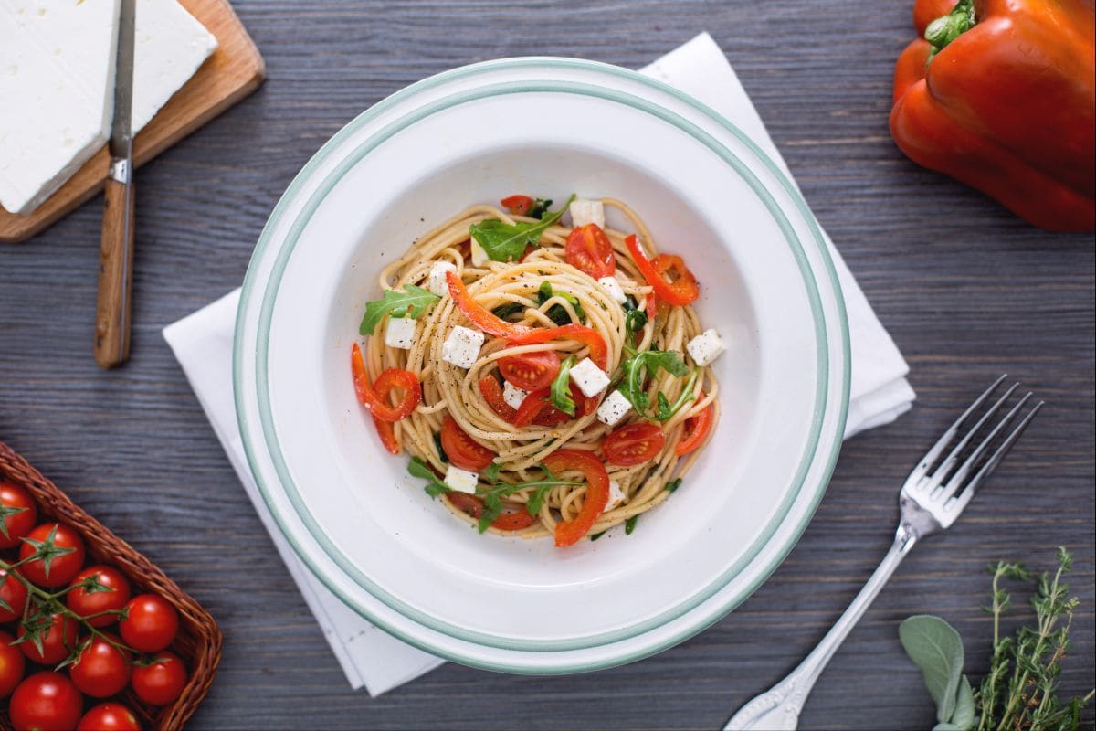 Whole wheat spaghetti with red peppers, arugula, and feta