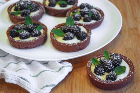 Cocoa tartlets with cream and blackberries