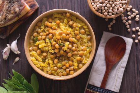 Pasta in chickpea soup with bay leaf and red garlic