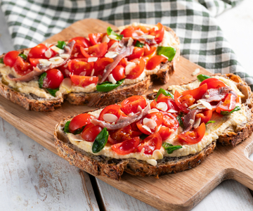 Bruschetta with cherry tomatoes, hummus and anchovies